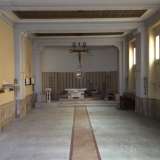 La cappella. Sul pavimento una striscia di color rosso porpora conduce all�abside circolare occupata dal presbitero rialzato di alcuni gradini rispetto al resto della chiesa, sul quale � posto un piccolo altare